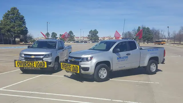 Two Bonafide pilot trucks with oversize load signs