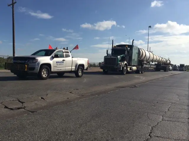 Bonafide pilot truck parked ahead of a long load