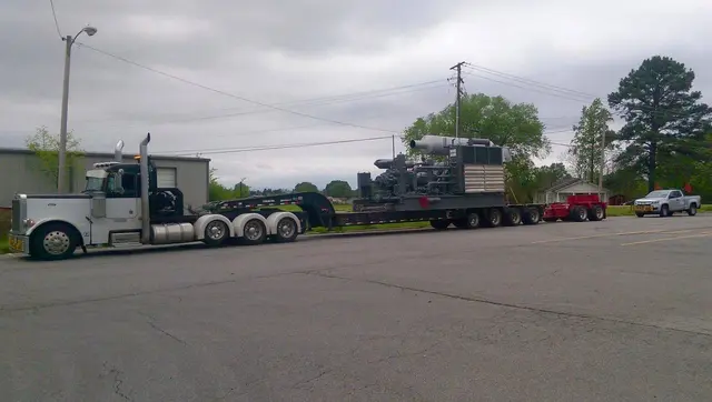 Heavy machinery load and a pilot truck in a lot