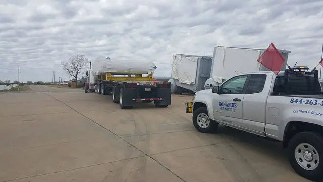 Bonafide pilot truck with flags beside white tank loads