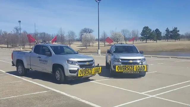 Two Bonafide pilot trucks with oversize load signs