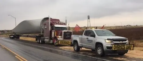 Bonafide pilot truck escorting a wind turbine blade on a wet road