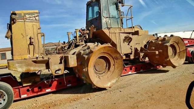 Compactor loaded on a lowboy trailer for an escorted move