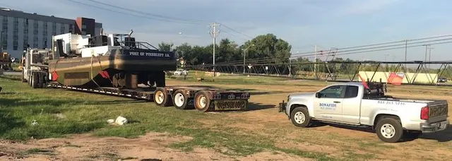 Bonafide pilot truck with a load on a lowboy trailer