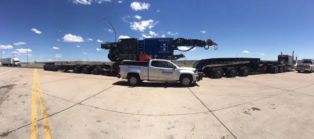 Bonafide pilot truck beside a large rig load