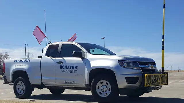 Bonafide pilot truck with a height pole and oversize load sign
